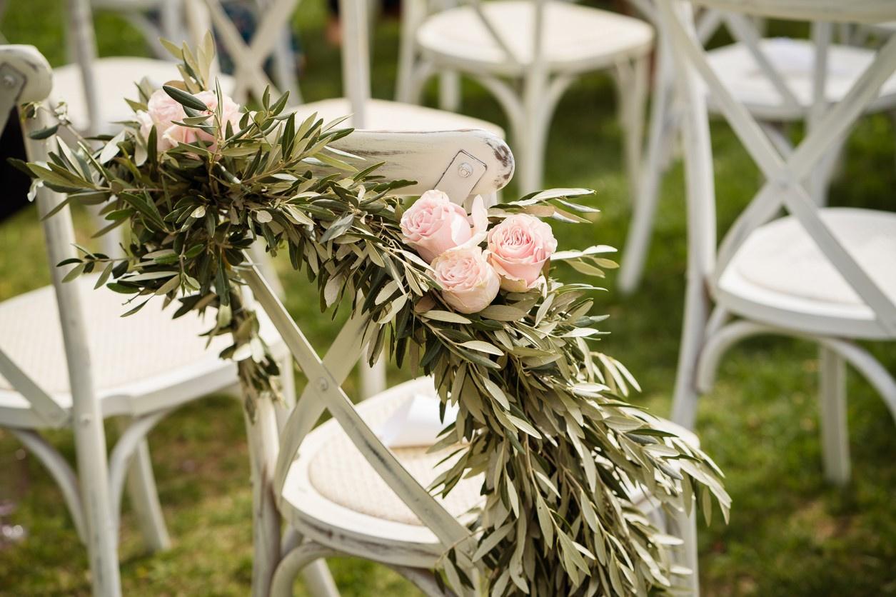 Scena da matrimonio con sedie bianche e rami d'ulivo